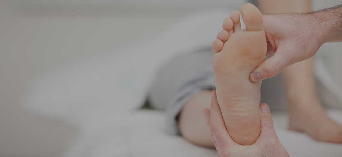 Doctor examining the bottom of a patient's foot.